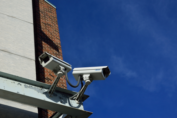 Dual outdoor CCTV surveillance cameras mounted on a commercial building for comprehensive 24/7 security monitoring.