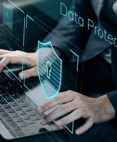 Hands typing on a laptop with a digital shield and lock icon, representing data protection, cybersecurity, data privacy, and secure information technology systems.